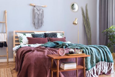 Tasarım mobilyalar, bal sarıkoltuk, gri makrame, altın lamba ve zarif aksesuarları ile yatak odası şık ve lüks iç. Güzel çarşaflar, battaniyeler ve yastıklar. Rahat ev dekorasyonu.