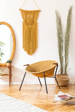 Tasarım altın koltuk, lamba, poster çerçeveleri ile oturma odası şık ve minimalist scandi iç. ayna, bitkiler, palmiye yaprakları, sarı makrame ve aksesuarları ile soyunma masası. Rahat ev dekorasyonu