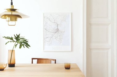 Poster haritası, masa tasarımı sandalyeler, altın pedant lamba ve kahve fincanpaylaşımı ile şık ve modern yemek odası iç. Beyaz duvarlar, ahşap parke. Vazodaki tropikal yapraklar. Eklektik dekor.