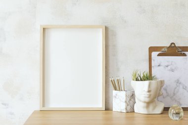 Soyut silinmiş duvarlar, altın kadar çerçeve kafa heykel, bitki ve ofis aksesuarları ile şık ve eklektik oda iç. Tasarım aksesuarları ile modern alan. Eklektik ev dekorasyonu. Gerçek fotoğraf. 