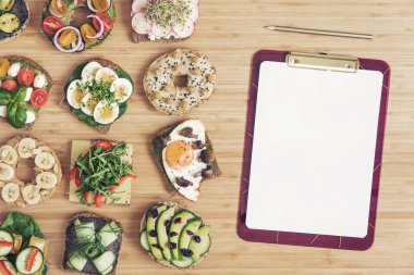 Vegan ve vejetaryen kahvaltı şık ve lezzetli kompozisyon. Sağlıklı beslenmenizi planlıyor. Tahta masada organik sebzeler ve sandviçler var. Menü konseptini taklit edin. Taze ve sağlıklı yemek. 