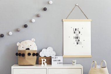 Sahte poster, beyaz raf, doğal oyuncaklar, asılı pamuk lambalar, bulut, aksesuarlar ve oyuncak ayılar için sepet ile çocuk odası şık ve sevimli İskandinav dekor. Aydınlık ve güneşli iç mekan.