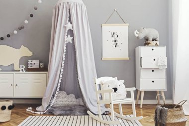 Sahte poster, beyaz tasarım mobilyalar, doğal oyuncaklar, yıldız, yastık, aksesuar ve oyuncak ayılar ile gri gölgelik asılı şık İskandinav yenidoğan bebek odası. Çocuk iç sevimli dekor. 
