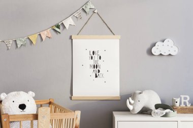 Sahte poster, doğal oyuncaklar, dekor bayrakları ve bulut, ahşap beşik, peluş gergedan ve oyuncak ayılar asılı ile yeni doğan bebek odası şık ve sevimli İskandinav dekor. Gri duvarlar.
