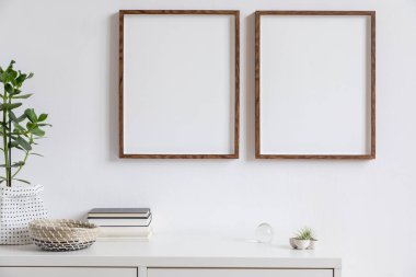 Kitap, şık tencere, hava bitkileri ve ev aksesuarları güzel bitki ile fotoğraf çerçeveleri kadar iki kahverengi ahşap sahte iç şık beyaz ev dekorasyonu. Minimalist İskandinav odası.