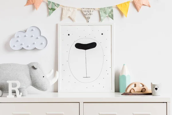 Poster çerçevesi, ahşap oyuncak, peluş gergedan, aksesuar ve bulutlar ile sahte modern İskandinav yenidoğan bebek odası. Pamuk lu bayraklar asmak. Çocuk odasıminimalist ve rahat dekor. Sahte konsept.