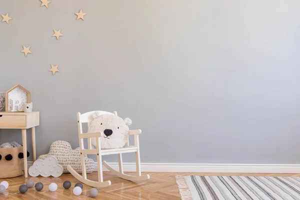 时尚的斯堪的纳维亚新生儿房 配有玩具 儿童椅 带泰迪熊的天然篮子和小搁板 现代内饰 灰色背景墙 木制镶木地板和星星图案 — 图库照片