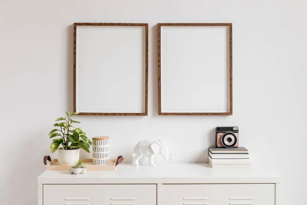 简约的家居装饰室内与两个棕色木制模拟相框的白色书架 美丽的植物在时尚的锅 即时相机 大象图和家庭配件 — 图库照片