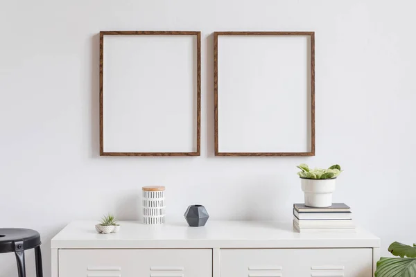 简约的家居装饰室内与两个棕色木制模拟相框的白色书架上的书籍 美丽的植物在时尚的锅 盒子和家庭配件 白色的墙壁模拟概念 — 图库照片