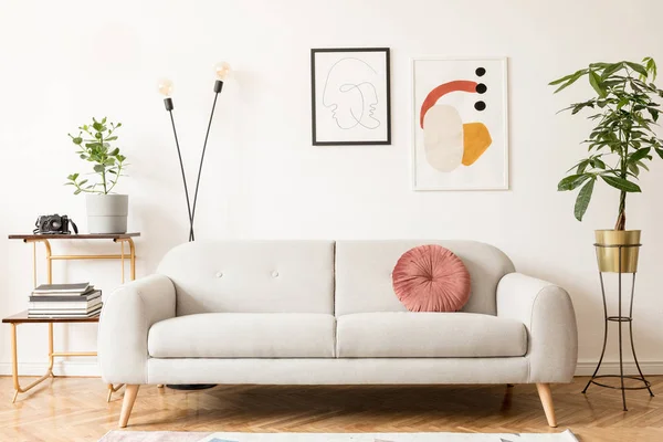 Şık retro ve tasarım kanepe ile oturma odası vintage iç, altın bookstand ve beyaz duvarlarda posterler çerçeveleri kadar sahte. Kahverengi ahşap parke ve bitkiler ile iç tasarım.