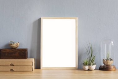 Ofis aksesuarları, kutular, şık tencerede güzel hava bitki ile kahverengi ahşap masada fotoğraf çerçevesi kadar sahte modern ev iç. Gri duvarlar. Ev ofis masasının minimal dekoru.