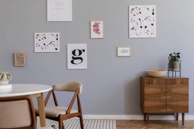 Gri kanepe, ahşap komodin ve küp, bitkiler ve zarif aksesuarlar ile güzel bir dairede oturma odası şık İskandinav iç. Posterler galeri duvar kadar mock. Modern ev dekorasyonu. 