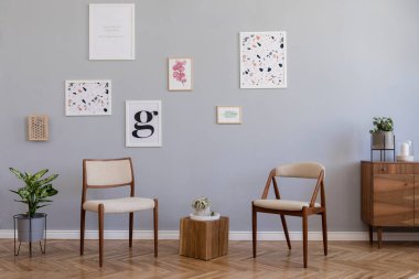 Poster çerçevesi, hava bitkileri, ahşap komodin ve zarif aksesuarlar ile sahte tasarım dairede oturma odası şık İskandinav iç. Gri arka plan duvarları. Modern ev dekorasyonu. Şablon