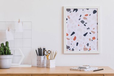 Ahşap masa, ofis malzemeleri, poster çerçevesi, kaktüsler ve zarif aksesuarlar kadar mock ile oturma odası Modern ve tasarım ev iç. Şık ve minimalist ev dekorasyonu. Şablon. Ev ofis alanı.