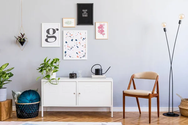 Design scandinavian home interior of open space with mock up posters gallery wall, white shelf, velvet chair, plants, lamp wooden cube and elegant accessories. Retro cozy home decor. Template.