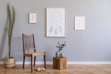 Retro sandalye, rattan terlik, ahşap küp, çiçekler, tropikal yaprakları, poster çerçeveleri ve zarif aksesuarlar kadar mock ile oturma odası Şık bohem iç tasarım. Modern ev dekorasyonu. Şablon