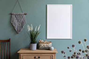 Beyaz mock up çerçeve, ahşap raf, retro sandalye, gri makrame, bitkiler, çiçekler, rattan sepet ve zarif aksesuarları ile oturma odası iç şık kompozisyon. Tasarım ev dekorasyonu. Şablon.