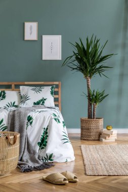 Ahşap yatak, bitki ve zarif aksesuarları ile yatak odası iç minimalist kompozisyon. Güzel çarşaflar, battaniye. Şablon. Tasarım ev dekorasyonu