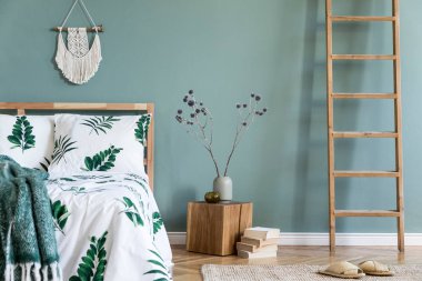 Ahşap yatak, bitki ve zarif aksesuarları ile yatak odası iç minimalist kompozisyon. Güzel çarşaflar, battaniye. Şablon. Tasarım ev dekorasyonu