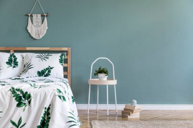 Ahşap yatak, bitki ve zarif aksesuarları ile yatak odası iç minimalist kompozisyon. Güzel çarşaflar, battaniye. Şablon. Tasarım ev dekorasyonu