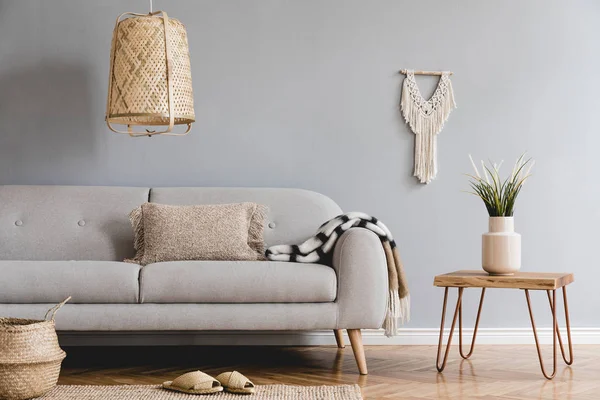 Gri kanepe, ahşap sehpa, yastık, rattan lamba ve zarif aksesuarları ile oturma odası şık ve tasarım ev iç. Şık ev dekorasyonu. Şablon. 