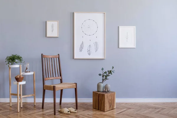 Stylish bohemian interior design of living room with retro chair, rattan slippers, wooden cube, flowerbed, plants, mock up poster frames and elegant accessories. Modern home decor. Template.