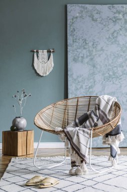 Tasarım rattan koltuk ve zarif aksesuarları ile oturma odası şık minimalist iç. Duvarın okaliptüs rengi. Kopyalama alanı