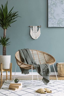 Tasarım rattan koltuk ve zarif aksesuarları ile oturma odası şık minimalist iç. Duvarın okaliptüs rengi. Kopyalama alanı