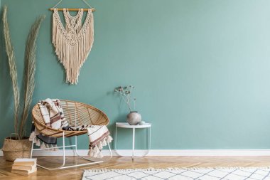 Tasarım rattan koltuk ve zarif aksesuarları ile oturma odası şık minimalist iç. Duvarın okaliptüs rengi. Kopyalama alanı
