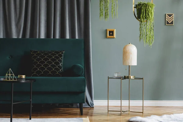 时尚豪华的客厅室内设计 配有绿色天鹅绒沙发 设计咖啡桌 大理石台灯 挂金花坛和典雅的配饰 现代家居装饰 — 图库照片