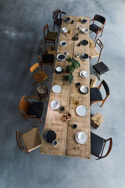 大きな木のテーブルと椅子のあるダイニングルームのインテリアテーブルの上の料理 — ストック写真