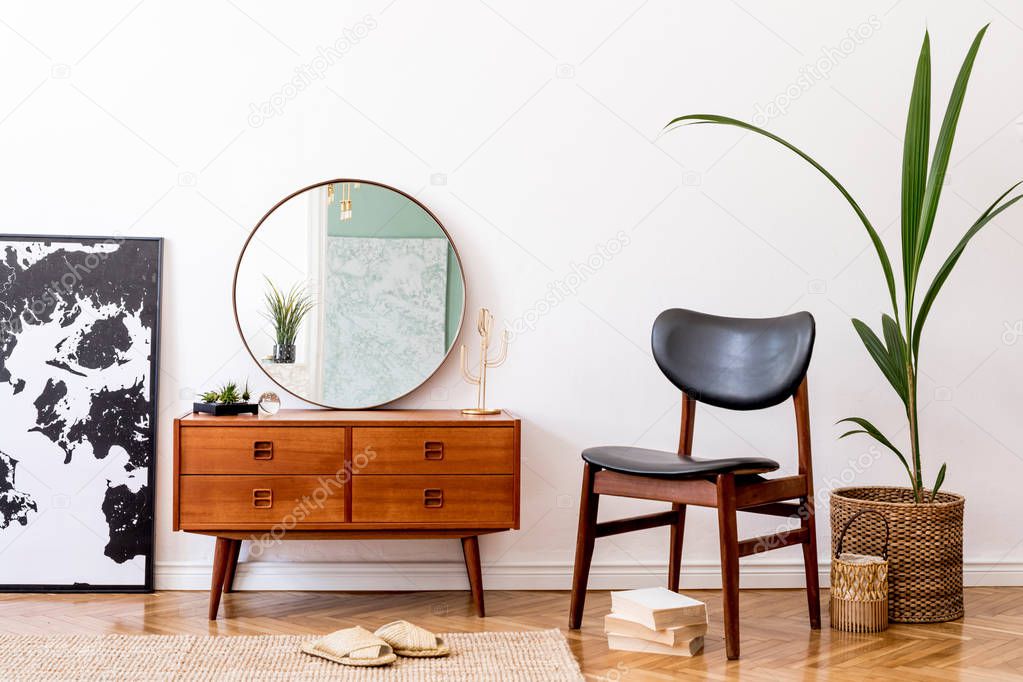 Stylish and modern interior of living room with elegant accessories. Round mirror and wooden commode