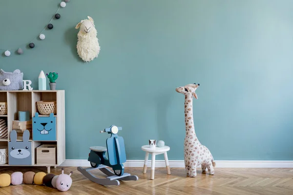 Scandinavian interior design of playroom with wooden cabinet, table, a lot of plush and wooden toys. Stylish and cute childroom decor. Eucalyptus background walls. Copy space. Template.