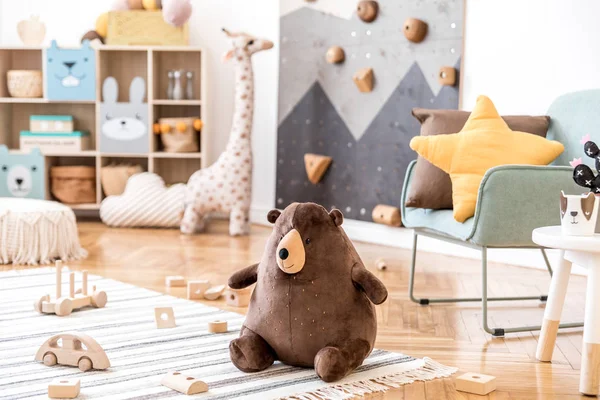 带有薄荷扶手椅的儿童房的现代丑闻式室内设计 儿童攀爬墙 家具设计 软玩具 玩具熊玩具和可爱的儿童用品 时尚的儿童房装饰 — 图库照片