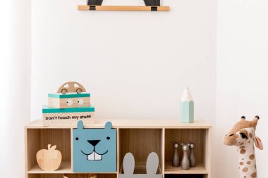 Ahşap dolabı, oyuncakları, kutuları ve peluş ayısı olan şık bir İskandinav çocuk odası. Beyaz duvarlar, oyun odasının minimalist dekorasyonu. Şablon. Boşluğu kopyala. 