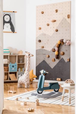 Çocuklar için modern tırmanma duvarı olan İskandinav iç tasarımı mobilyalar, çocuk oyuncakları, yumuşak oyuncaklar, oyuncak ayı ve şirin çocuk aksesuarları. Şık bir çocuk odası dekoru. Şablon.