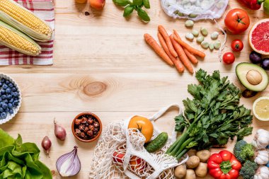 Mutfaktaki ahşap masada taze sağlıklı sebzelerin ve meyvelerin modern kompozisyonu. Sağlıklı detoks ve denge diyeti. Yaşam tarzı. Vejetaryen vejetaryen geçmişi. Sıfır kayıp. Üst Manzara. Boşluğu kopyala.
