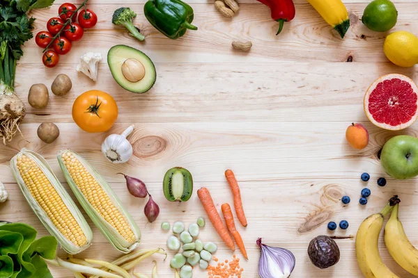 Mutfaktaki ahşap masada taze sağlıklı sebzelerin ve meyvelerin modern kompozisyonu. Sağlıklı detoks ve denge diyeti. Yaşam tarzı. Vejetaryen vejetaryen geçmişi. Sıfır kayıp. Üst Manzara. Boşluğu kopyala.