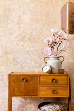 Oturma odasının içinde ahşap klasik tuvalet, altın rengi ayna, bitki, rattan sepet, ekose, dekorasyon ve Wabi Sabi ev dekorunda zarif kişisel aksesuarları olan eski kompozisyon..