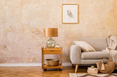 Kahve masası, masa lambası, tasarım gri kanepe, resim çerçevesi, kitaplar, halı, kadın çantası, yastık, ekose ve zarif aksesuarlı ev dekorları..