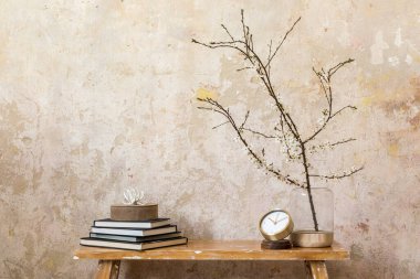 Oturma odasında tasarım saati, ahşap tezgah vazoda kurumuş çiçekler, grunge duvar ve modern ev dekorunda zarif kişisel aksesuarlar ile şık bir kompozisyon. Boşluğu kopyala.