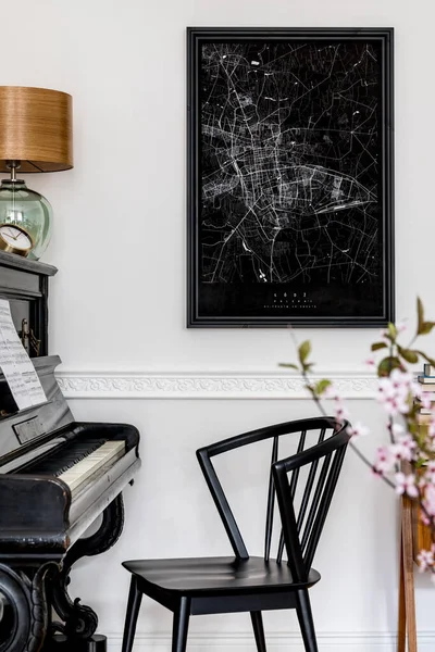 Stylish composition at living room interior with black piano, design chair, black mock up poster map, spring flowers, lamp, furniture and elegant presonal accessories in modern home decor.