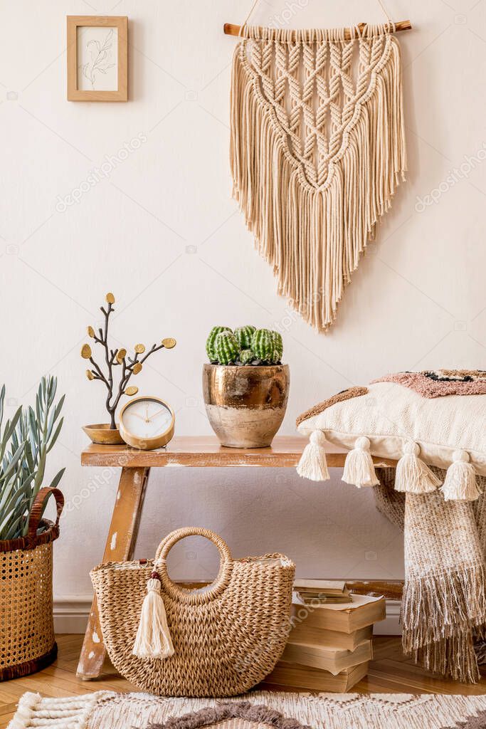 Stylish composition of living room interior with mock up frame, wooden bench, pillow, plaid, woman bag, books, cacti, macrame, plant, decortaion and elegant personal accessories in modern home decor.