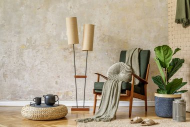 Dizayn koltuğu, lamba, rattan dekoru, tepside çaydanlık, tropikal yaprak, bitki halısı ve wabi sabi konseptinde zarif presonal aksesuarlarla modern oturma odası iç dekorasyonu..