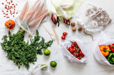 Mermer masada sıfır çöp torbası, fındık, tohum, yumurta, biyolojik sebze ve eko meyveli şık bir kompozisyon. Dünyayla ilgilenmek. Plastiği durdur.