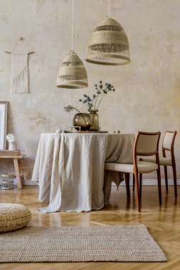 Lokanta masası, tasarım sandalyeleri, kolye lambaları, vazolarda kurutulmuş çiçekler, mobilyalar, dekorasyon ve rahat ev dekorasyonunda zarif kişisel aksesuarları olan şık ve şık bir yemek odası..