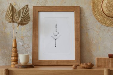 Oturma odasının içi, poster çerçevesi, zarif aksesuarlar, vazoda kurumuş çiçekler, ahşap konsol ve şık ev dekorunda sallanan rattan kulübesi..