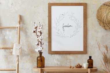 Oturma odasının içinde poster çerçevesi, zarif aksesuarları, vazoda kurumuş çiçekleri, ahşap konsolu ve şık ev dekorunda sallanan rattan kulübesi var. Şablon.