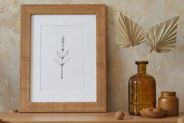 Oturma odasının içi, poster çerçevesi, zarif aksesuarlar, vazoda kurumuş çiçekler, şık ev dekorunda ahşap konsol. Minimalist bir kavram. Şablon.