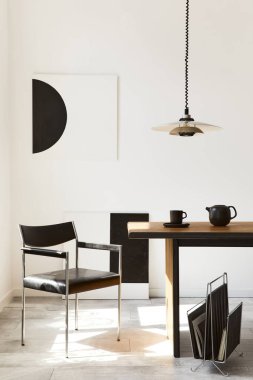 Tasarım ahşap aile masası, siyah sandalyeler, fincanlı çaydanlık, duvarda sanat resimleri ve modern ev dekorunda zarif aksesuarları olan şık bir yemek odası. Şablon.